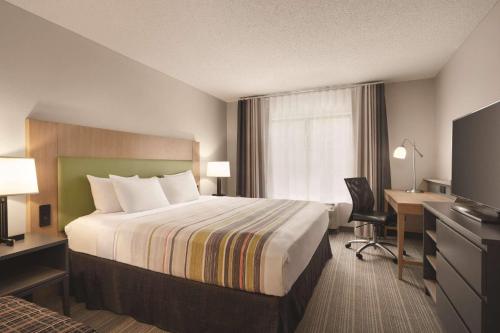 a hotel room with a bed and a desk with a computer at Country Inn & Suites by Radisson Raleigh-Durham Airport NC in Morrisville