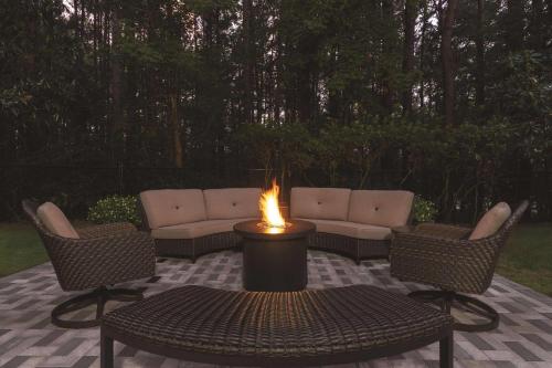 a fire pit with two chairs and a table with a fire burns at Country Inn & Suites by Radisson Raleigh-Durham Airport NC in Morrisville