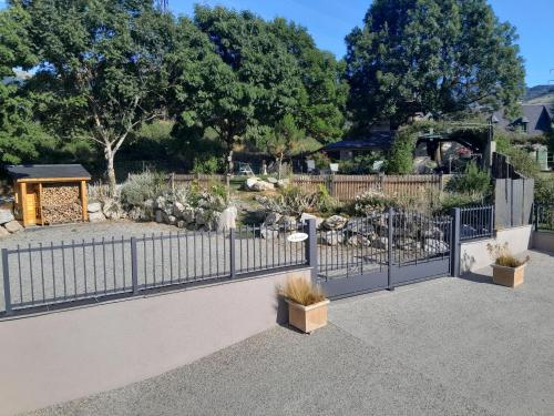 a fence in front of a garden with plants at grange rénovée en gîte/maison/chalet in Arreau