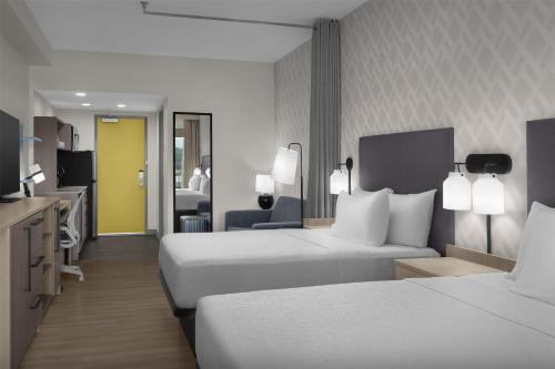 a hotel room with two beds and a television at Home2 Suites By Hilton Sevierville in Pigeon Forge