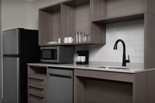 a kitchen with a sink and a microwave at Home2 Suites By Hilton Sevierville in Pigeon Forge