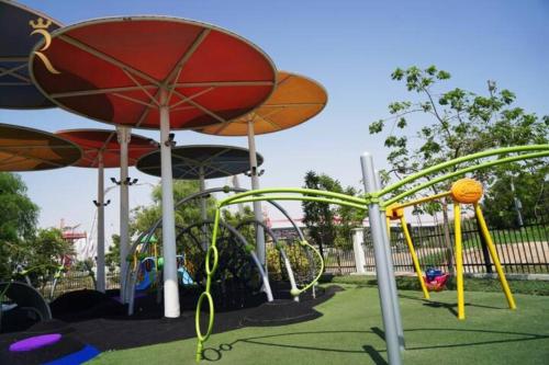 a park with a playground with slides at Supernova Haven 1BR - Peaceful Poolside Getaway Near Yas Mall & Marina in Abu Dhabi