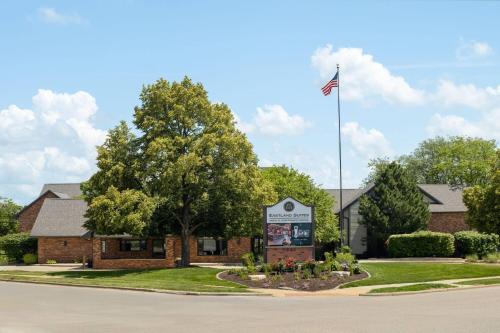 a building with an american flag in front of it at Eastland Suites Hotel & Conference Ctr, Trademark by Wyndham in Bloomington