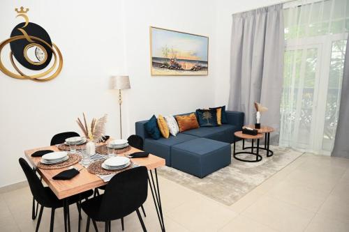 a living room with a blue couch and a table at Supernova Haven 1BR - Peaceful Poolside Getaway Near Yas Mall & Marina in Abu Dhabi