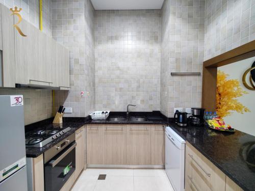 a kitchen with a sink and a stove at Supernova Haven 1BR - Peaceful Poolside Getaway Near Yas Mall & Marina in Abu Dhabi