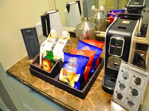a counter with food and a coffee maker on it at Jinjiang Metropolo Hotel Classiq YMCA People Square in Shanghai