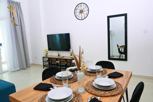 a dining room with a table with chairs and a mirror at Supernova Haven 1BR - Peaceful Poolside Getaway Near Yas Mall & Marina in Abu Dhabi