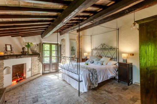a bedroom with a bed and a fireplace at Respiro Umbria, 1500s Villa with Unique Biopool in Spoleto