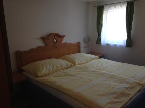 a large bed in a bedroom with a window at Haus Julia in Mühlbach am Hochkönig