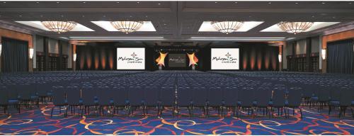 a large room with a stage with chairs and screens at Mohegan Sun in Uncasville