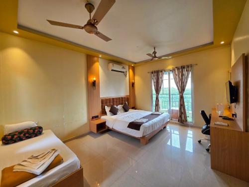 a hotel room with two beds and a tv at Relax Adventure Resort in Igatpuri
