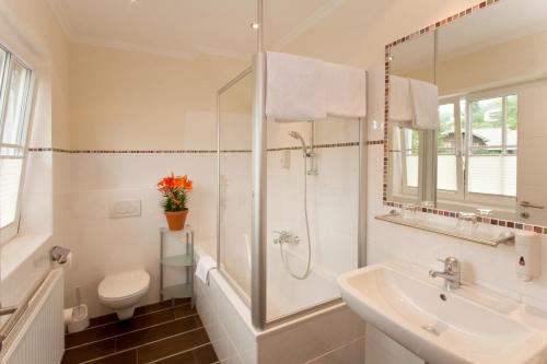 a bathroom with a shower and a sink and a toilet at Hotel Krone in Mondsee