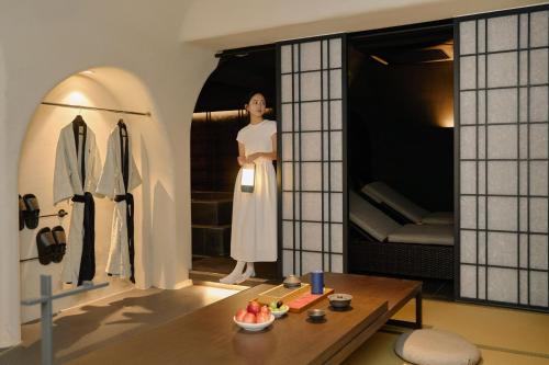 a woman in a white dress standing in a room at Cave Ryokan Hotel by Aank Sungshin Women's University in Seoul