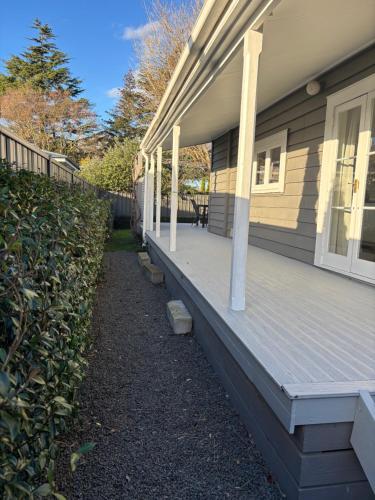 a front porch of a house with a wooden deck at Luxury Village Villa 200metres from Village in Havelock North