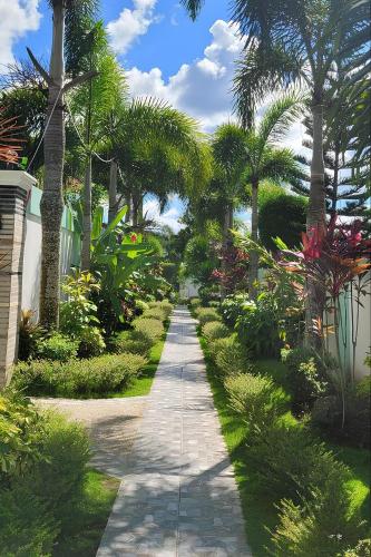 a garden with palm trees and a walkway at Jewelry Resort and Villas Tagaytay in Silang