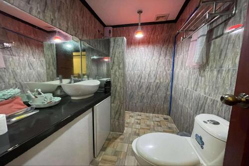a bathroom with a toilet and a sink and a mirror at Jewelry Resort and Villas Tagaytay in Silang