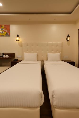 two beds sitting next to each other in a room at Hotel 99 Villa in New Delhi