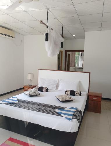 a large white bed with two pillows on it at Sudunelum Holiday Resort in Anuradhapura