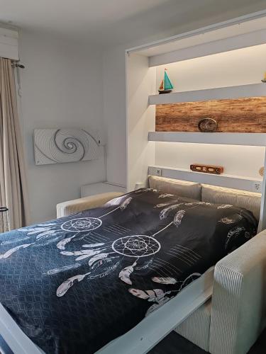 une chambre avec un lit avec un tableau dessus dans l'établissement Studio SAM - Face à la Mer, à Port-la-Nouvelle