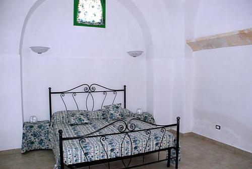 a black bed in a white room with a window at La Casa Del Massaro in Oria