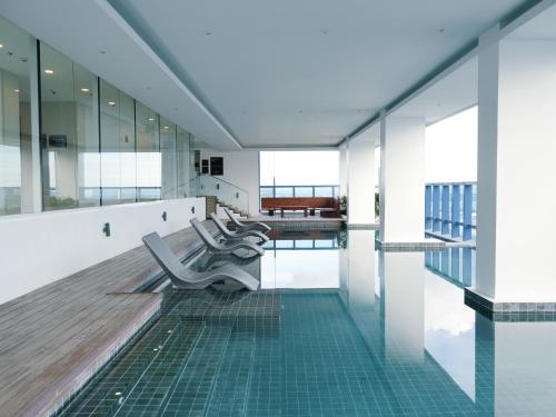 a swimming pool with benches in a building at Sky High Living at 38 Park Avenue in Cebu City
