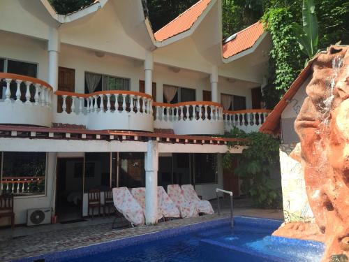 a hotel with a swimming pool in front of a building at Hotel Coco Beach in Manuel Antonio