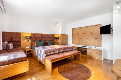 a bedroom with a bed and a couch and a television at Ferienwohnung Fenzl in Johanngeorgenstadt