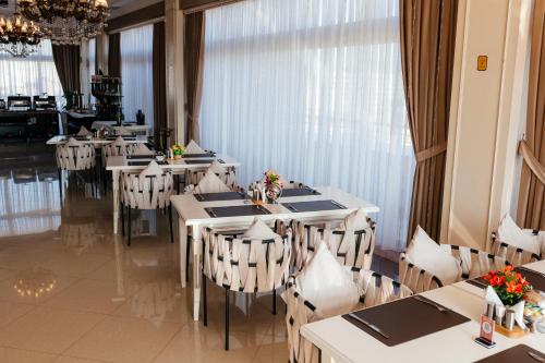 a dining room with tables and chairs in a restaurant at Capitol Hotel Stay in Baku