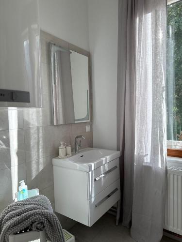 a white bathroom with a sink and a mirror at Ferienwohnung Klapothek in Leutschach