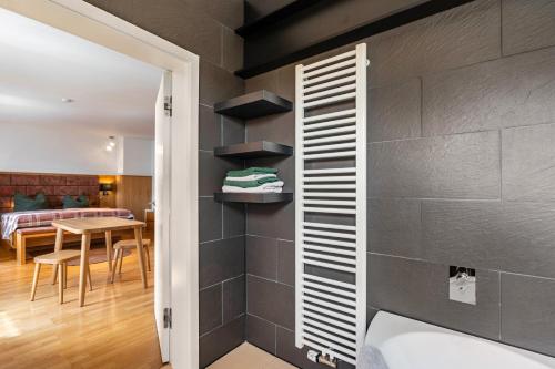 a bathroom with a black wall with shelves and a tub at Ferienwohnung Fenzl in Johanngeorgenstadt