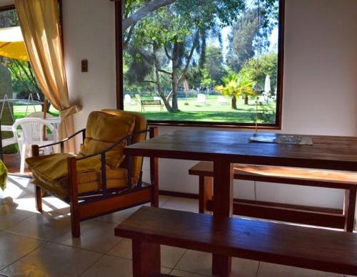 a dining room with a table and a chair and a window at Stellamar Apart Hotel in La Serena