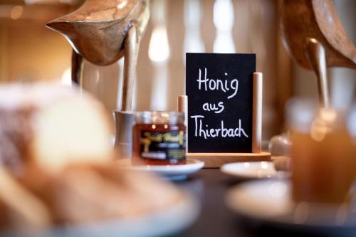 a table with a bottle of honey and a sign at Pension Schneerose - Wildschönau - PREMIUM CARD im Sommer in Wildschönau