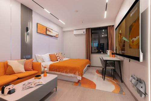 a room with a bed and a couch and a tv at The Bund River Prologue Residence in Shanghai