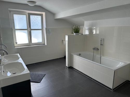 a white bathroom with a tub and a sink at Haus Berlin in Hagen