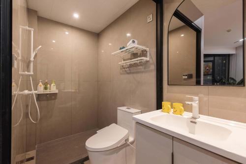 a bathroom with a toilet and a sink and a mirror at The Bund River Prologue Residence in Shanghai