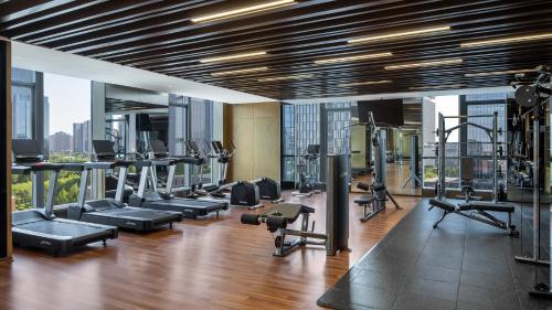 a gym with a lot of treadmills and machines at InterContinental Hotels Zhengzhou Zhengdong in Zhengzhou