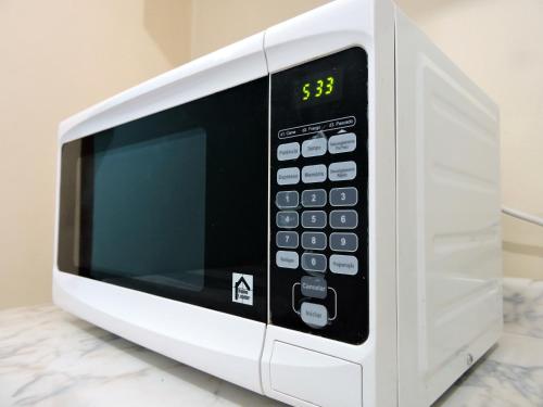 a white microwave oven sitting on top of a counter at 10 Studios in Sao Paulo