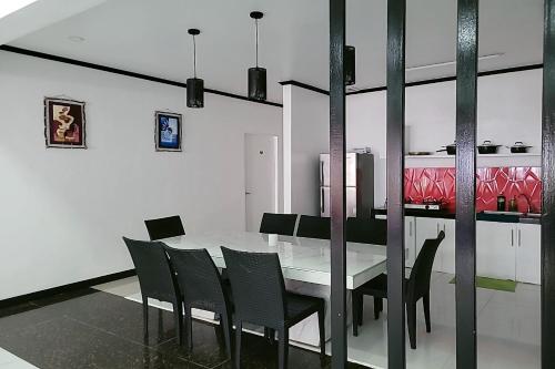 a dining room with a white table and black chairs at Jewelry Resort and Villas Tagaytay in Silang
