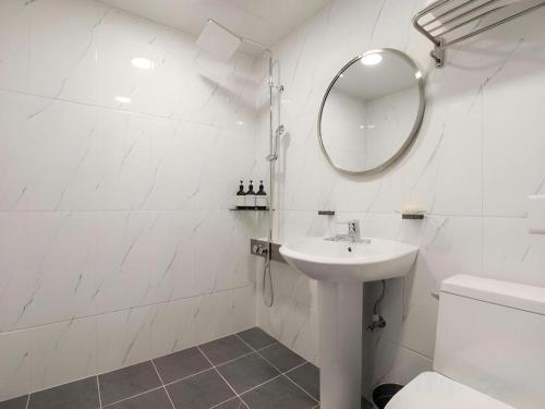 a white bathroom with a sink and a mirror at Chuncheon World Hotel in Chuncheon