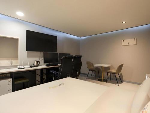 a room with a desk and a computer and chairs at Chuncheon World Hotel in Chuncheon