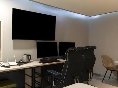 an office with a desk with two monitors and a chair at Chuncheon World Hotel in Chuncheon