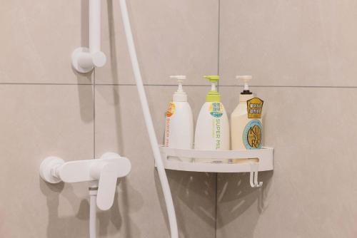 a rack with four bottles of cleaning products in a bathroom at The Bund River Prologue Residence in Shanghai