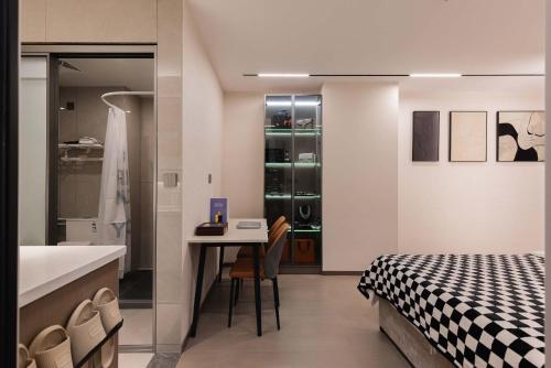 a bedroom with a bed and a table and a kitchen at The Bund River Prologue Residence in Shanghai