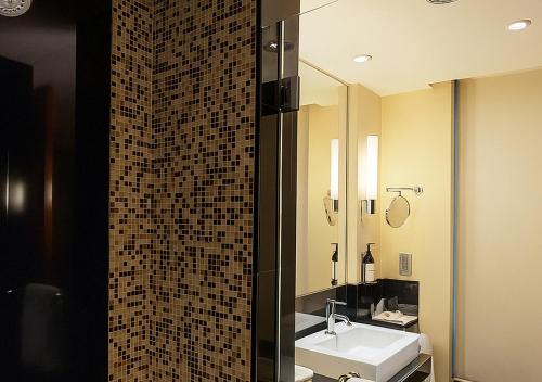 a bathroom with a sink and a mirror at Hyatt Hyderabad Gachibowli in Hyderabad