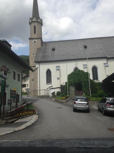a church with a car parked in front of it at Haus Julia in Mühlbach am Hochkönig