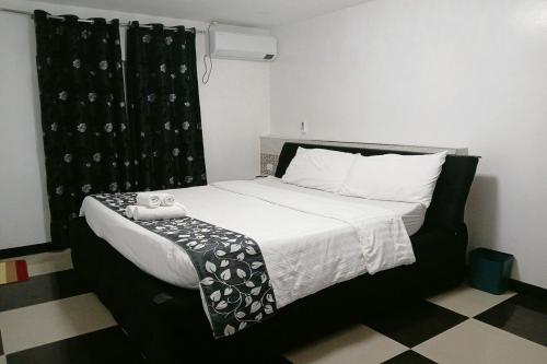 a bedroom with a bed with a black and white comforter at Jewelry Resort and Villas Tagaytay in Silang