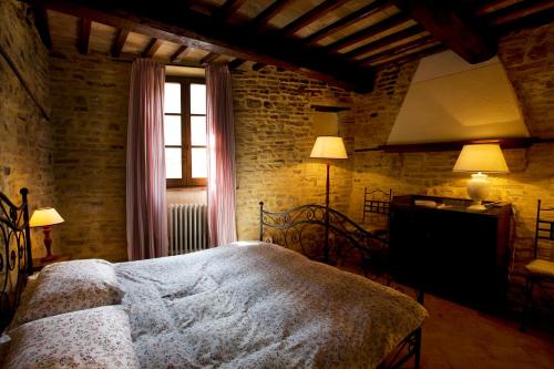 a bedroom with a bed and a window and a television at L’Arco Romanico in Montefalco