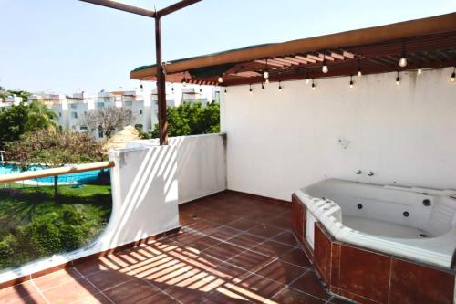 a bath tub on a patio with an umbrella at Residencia en Club Náutico Tequesquitengo in Tequesquitengo