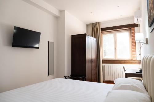 a bedroom with a bed and a tv on the wall at Tenuta Madre Vita in Siracusa