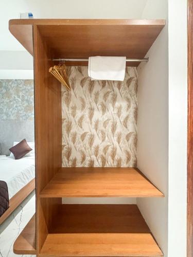 a small closet in a room with a bed at The Monarch Hotel Bagalur IT Park in Bengaluru